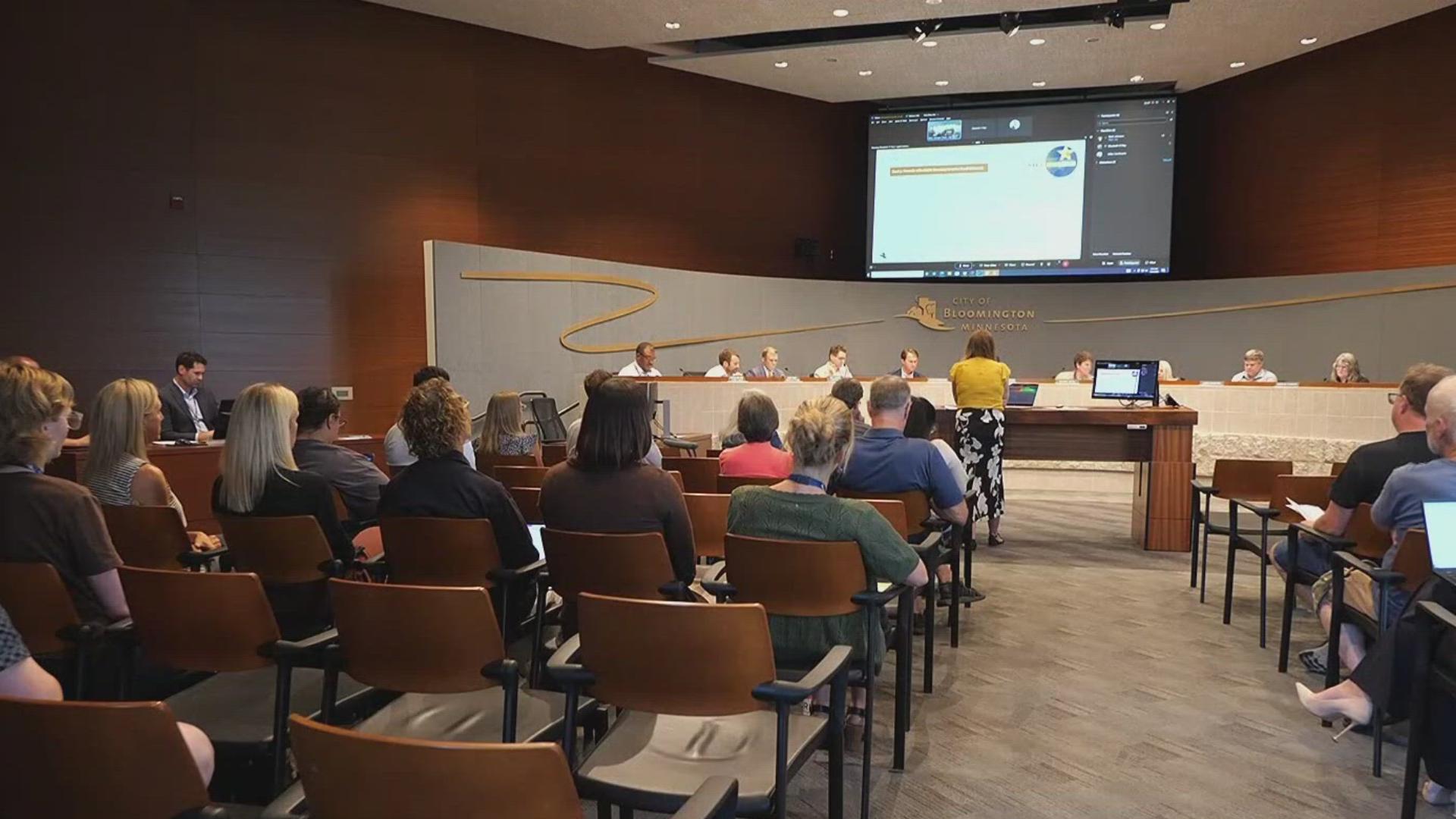 A crowded Bloomington Planning Commission meeting. Attendees look on from the audience as city staff present to comissioners at the dais.